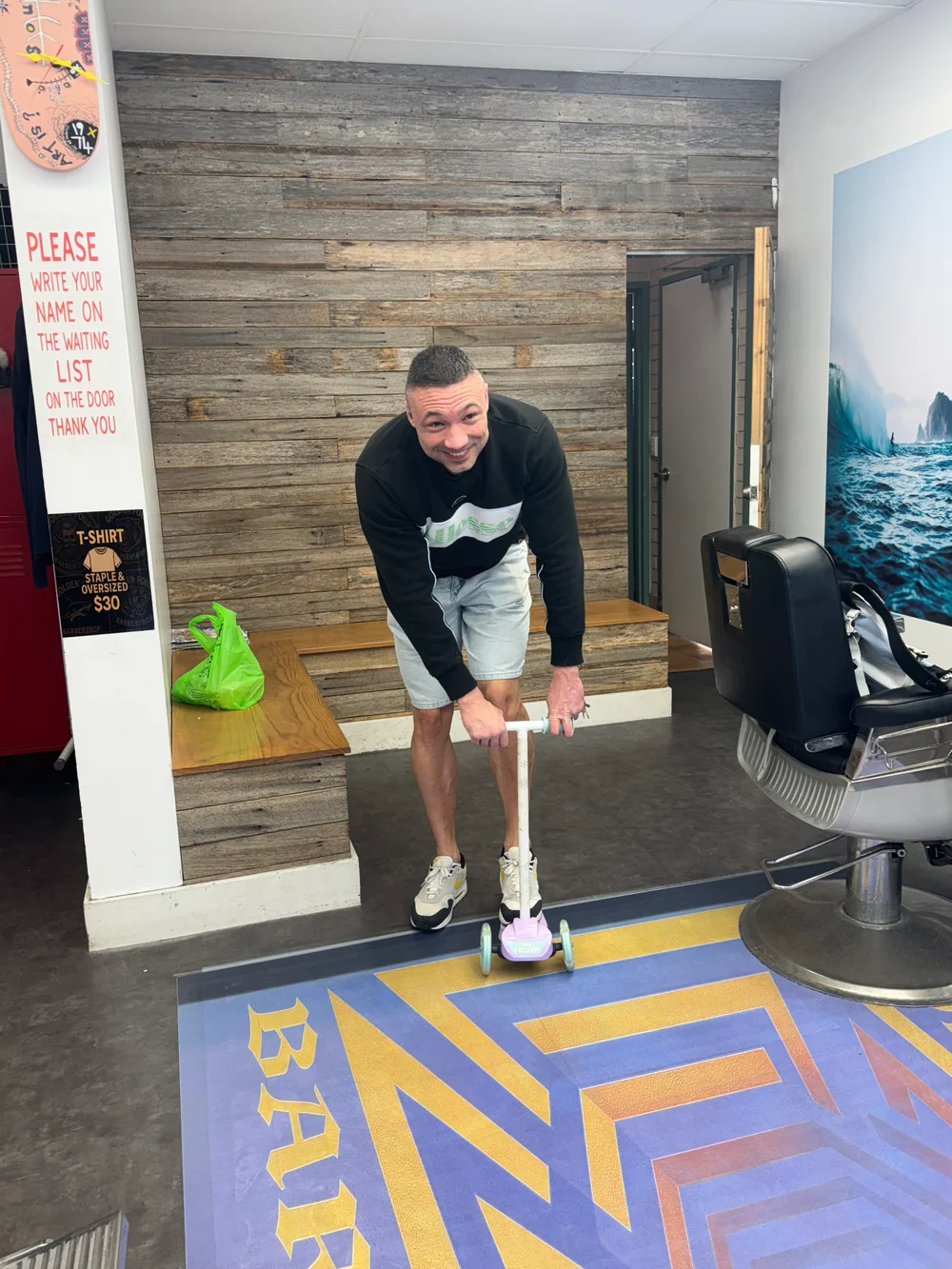 A visitor having fun on a scooter inside the barbershop