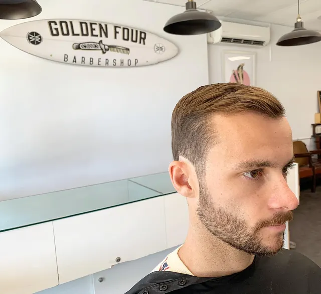 Side-part haircut and shaped beard at Golden Four