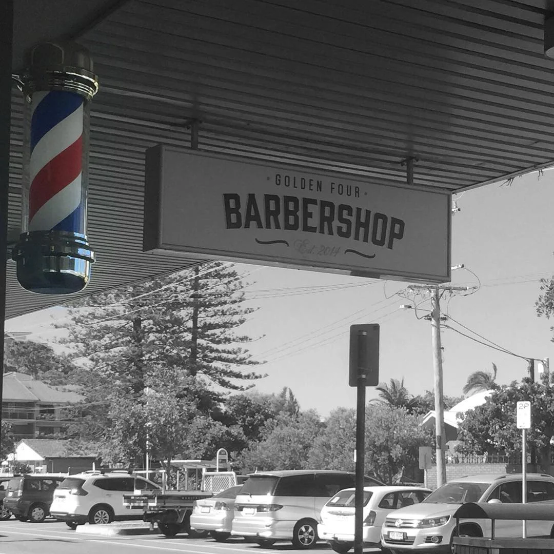 Golden Four’s hanging barbershop sign and red, white and blue barber pole in Tugun